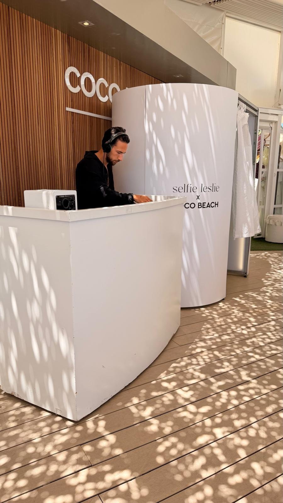 DJ station next to white branded photo booth at Coco Beach Ibiza brand activation